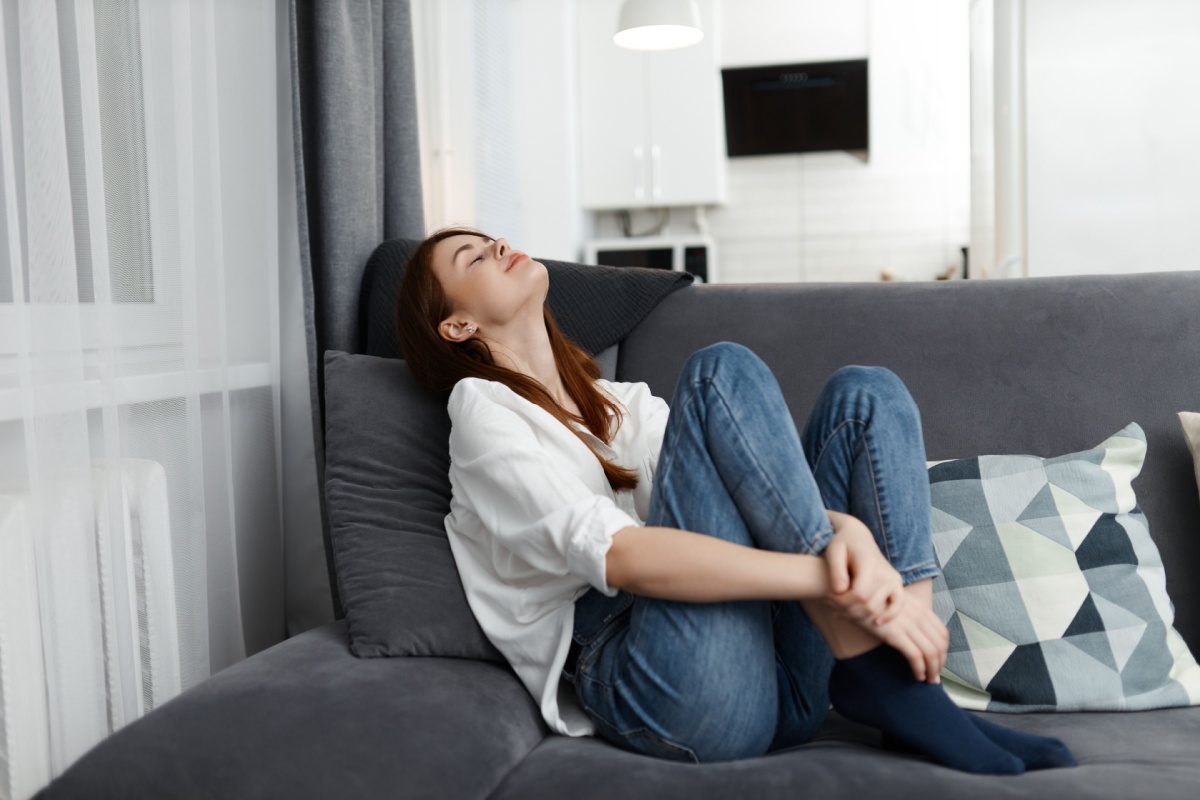 woman relaxing on the couch, taking in a deep breath of air