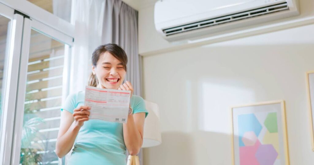 happy woman looking at a utility bill because she saved money on air conditioning