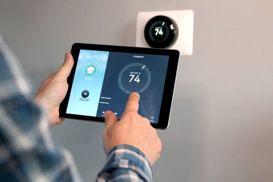 Homeowner controlling the temperature on their smart thermostat through an iPad